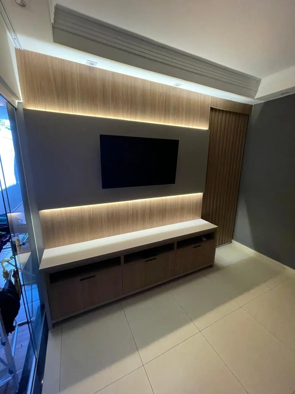 Home planejado com painel iluminado em LED e rack