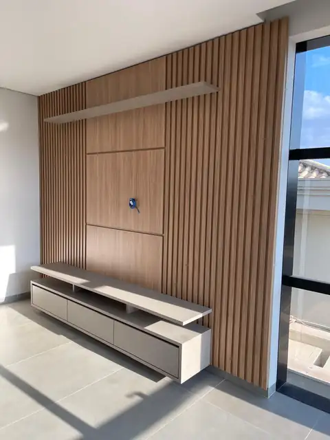 Home planejado com painel ripado e rack